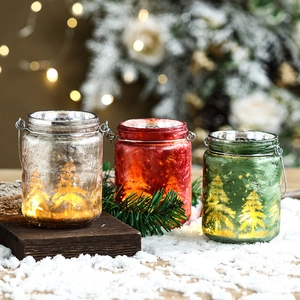 Three Christmas glass candle holders in red, silver, and green with warm LED lighting