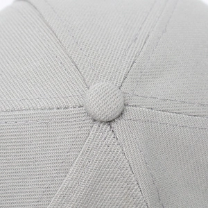 Close-up of the grey baseball cap top showing high-quality stitching and fabric texture