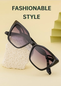 Fashionable cat eye sunglasses with purple gradient lenses on minimalist props
