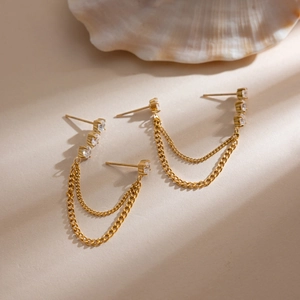 Detailed close-up of 18K gold-plated double-piercing earrings with zircon tassels