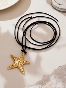 Détail macro du pendentif étoile de mer plaqué or 18k avec texture sur cordon noir
