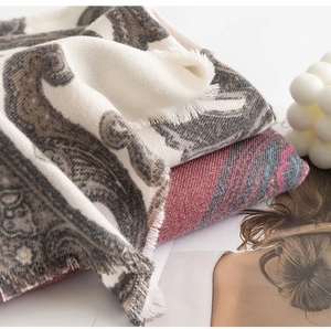 Close-up of beige paisley pashmina shawl with tassel fringe and thick cashmere-like texture