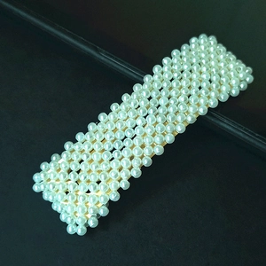 Detailed view of handmade rectangular hair clip with white pearls on gold metal base