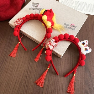 Detailed close-up of festive red New Year headbands with plush horse and lion motifs