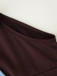 Détail de l'encolure du haut en satin marron avec des coutures à double aiguille précises