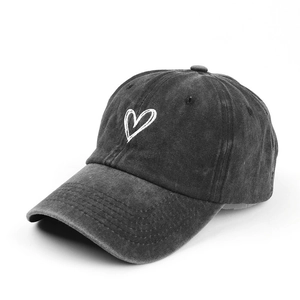 Washed black denim baseball cap with white embroidered heart and vintage texture