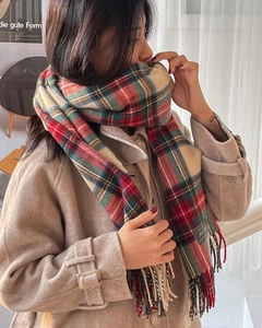 Detailed close-up of Christmas red and green plaid tassel scarf with soft wool texture