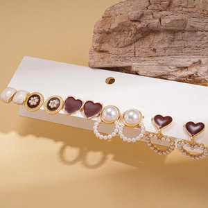 Elegant 6-pair gold metal earring set with brown enamel and faux pearls on a white card