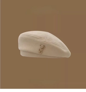 Detailed close-up of beige tweed beret featuring a 3D brown bear charm decoration