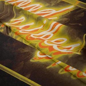 Detail of vibrant orange and yellow flame-style script printing on soft black fabric