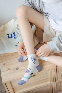 Détail de chaussettes blanches en coton avec motif tulipe violette et texte Welcome