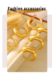 Detail of chunky C-shape golden hoop earrings displayed in a beige velvet jewelry box