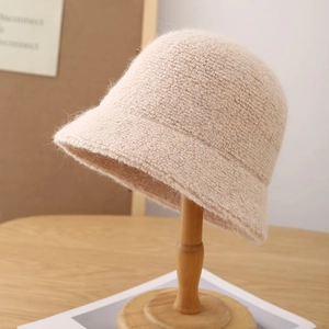 Gros plan du chapeau cloche en maille beige avec texture épaisse sur support en bois