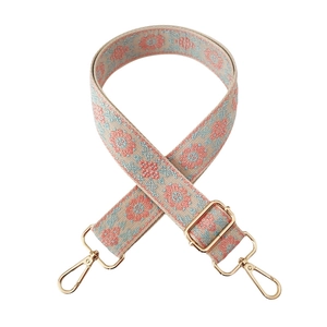 Detail of adjustable 3.8cm jacquard shoulder strap with gold hooks and floral patterns