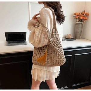 Detailed view of beige hand-woven crochet tote bag featuring vibrant yellow tassels