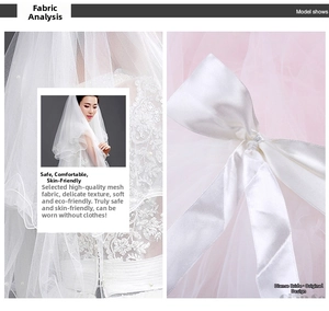 Detail of soft white tulle bridal veil with elegant satin bow and floral lace embroidery