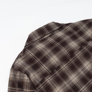 Détail du revers et de l'épaule d'une chemise vintage à carreaux marron cintrée