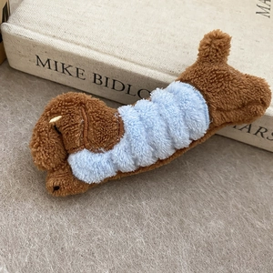 Detailed macro shot of a brown plush puppy hair clip with soft fuzzy texture