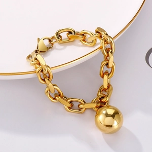 Detailed close-up of a gold-plated chunky chain bracelet with a large polished ball charm