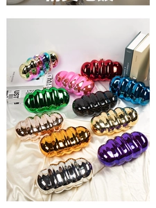 Flat lay of metallic cloud acrylic evening clutch bags in multiple colors on silk