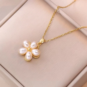 Elegant gold flower pearl pendant necklace displayed in a beige jewelry gift box
