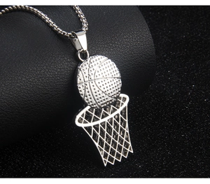 Close-up of silver stainless steel basketball and hoop pendant necklace on black background