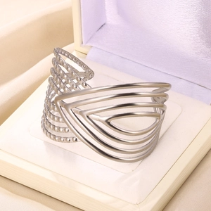 Detailed close-up of a wide multi-layer stainless steel cuff bracelet on satin