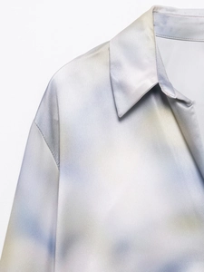 Detailed close-up of a satin tie-dye shirt collar with elegant gradient patterns