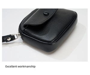 Detail of black litchi grain leather coin purse with silver zipper and fine stitching