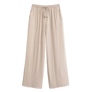 Detail der hellbeigen weiten Hose mit Leinentextur und Kordelzug mit Holzperlen verzierung