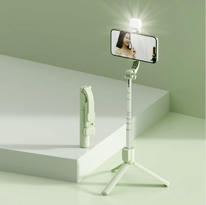 Detail of green selfie stick showing the foldable tripod base and detachable fill light