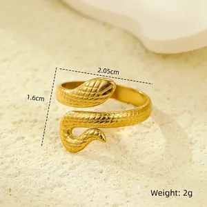 Detailed close-up of a gold-plated snake ring with intricate scale textures on a stone base