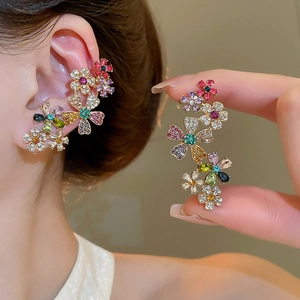 Macro shot of 18k gold plated flower ear cuff with colorful rhinestones on a model