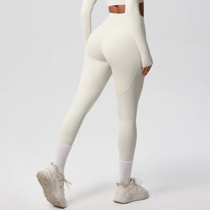 Close-up of high-waisted yoga leggings showing the booty-lifting seam and creamy white fabric