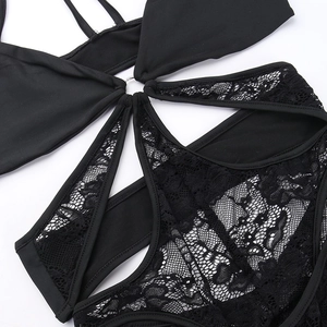Detail of black lace bodysuit with metallic ring connector and mesh hollow-out design