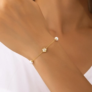 Dettaglio del bracciale in argento S925 con fiore bianco a cinque petali e perle tonde