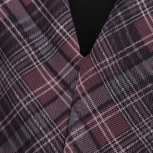 Macro shot of dark purple plaid fabric texture and V-neckline detail on vintage dress