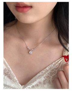 Close-up of S925 sterling silver necklace with sparkling round zircon pendant on model