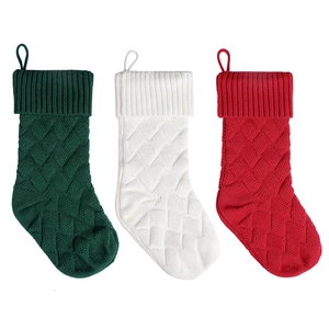 Set of three large knit Christmas stockings in red white and green with cable patterns