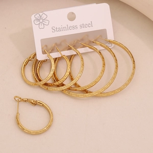 Detail of six pairs of gold stainless steel hoop earrings with Greek meander pattern engraving