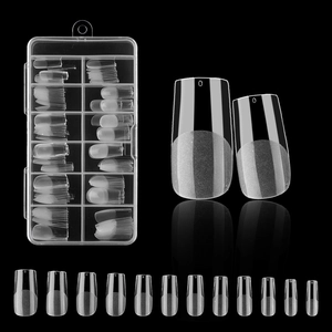 Macro detail of clear press-on nails in 12 sizes with a storage box on a black background