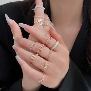 Detailed close-up of gold starfish and geometric rings layered on a model hand