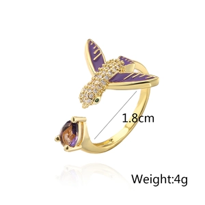 Detail view of 18K gold plated hummingbird ring with purple enamel wings and zircons