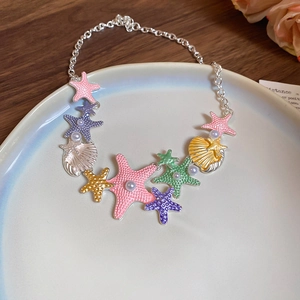 Detailed close-up of colorful starfish and shell charms with faux pearls on silver chain
