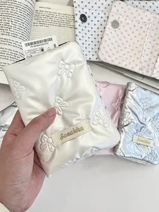 Quilted bow passport holder in white, pink, and blue satin for travel storage