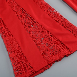 Gros plan sur un tissu en dentelle florale rouge montrant des textures ajourées