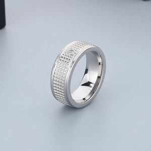 Macro shot of titanium steel ring featuring grid texture and a single inset diamond