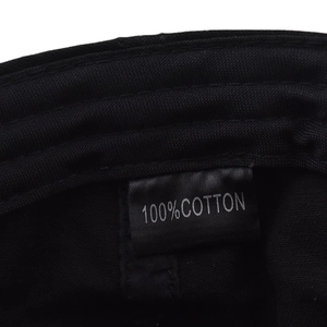 Macro view of 100% cotton fabric interior and stitched product label on black beret hat