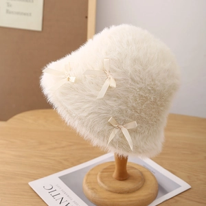 Detail shot of soft cream white faux fur bucket hat featuring silky decorative bows