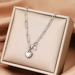 Detailed view of silver heart pendant necklace on a champagne gold jewelry box